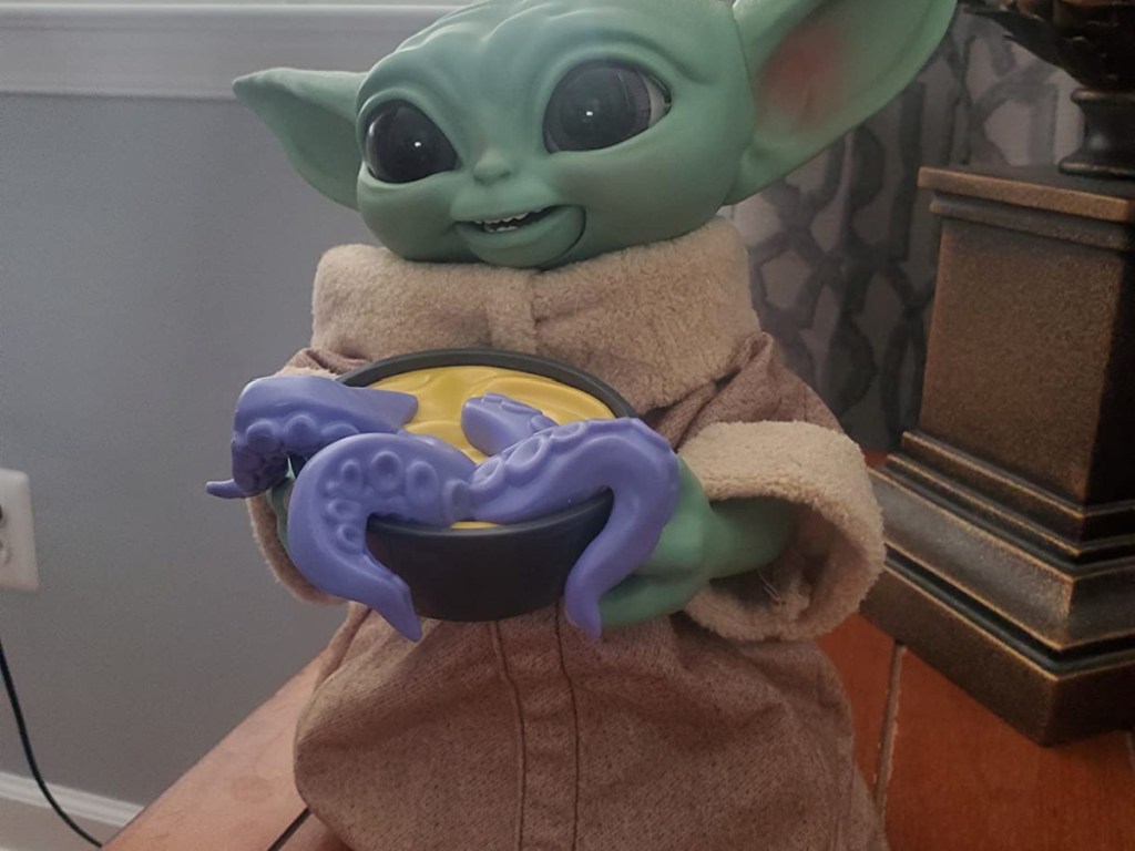 Baby Yoda toy holding squid toy