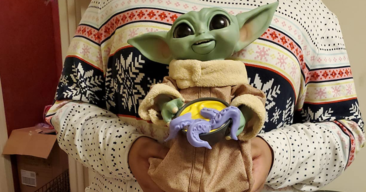 Woman holding baby yoda toy
