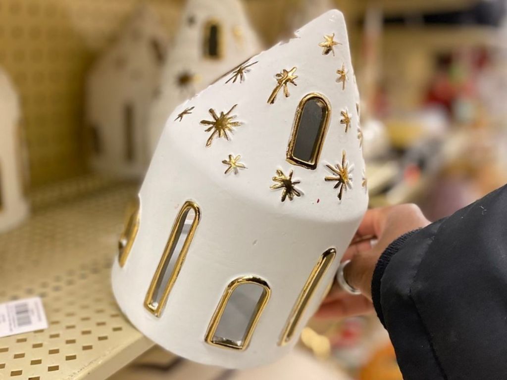 holding white and gold nativity house