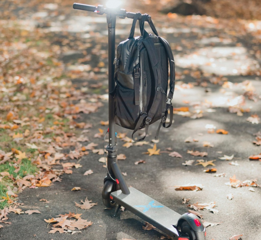 backpack hanging on black scooter outside