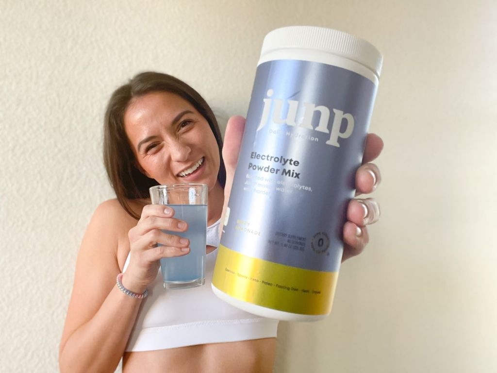 woman holding a container of JUNP drink mix