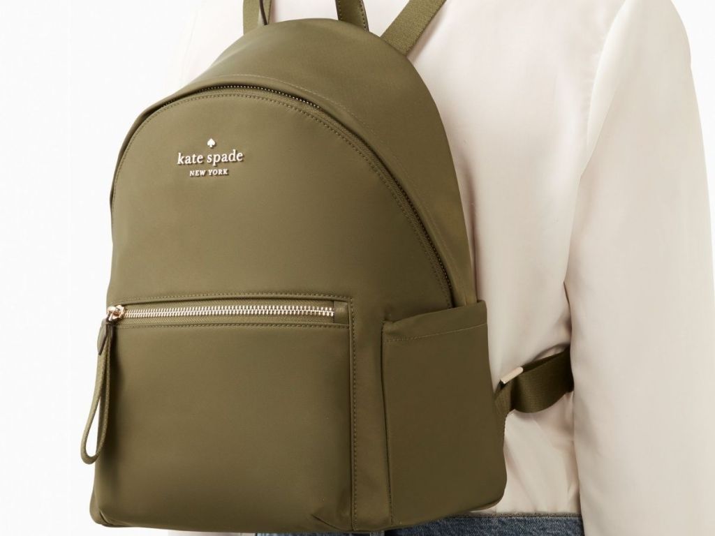 woman wearing green Kate Spade backpack