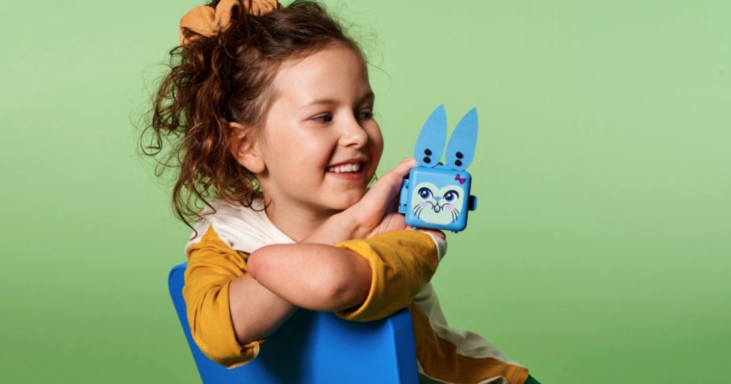 little girl holding blue lego shaped bunny box