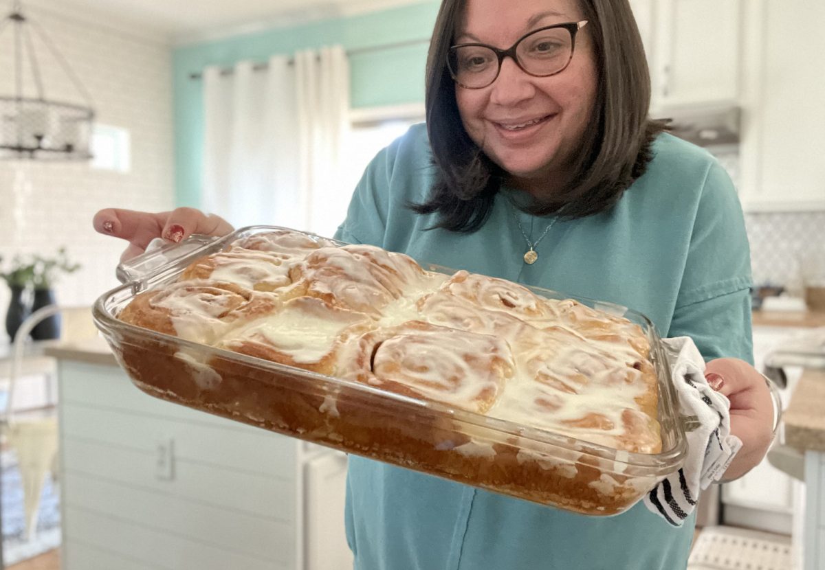 Woman holding a pan of rolls made with her cinnamon rolls hack