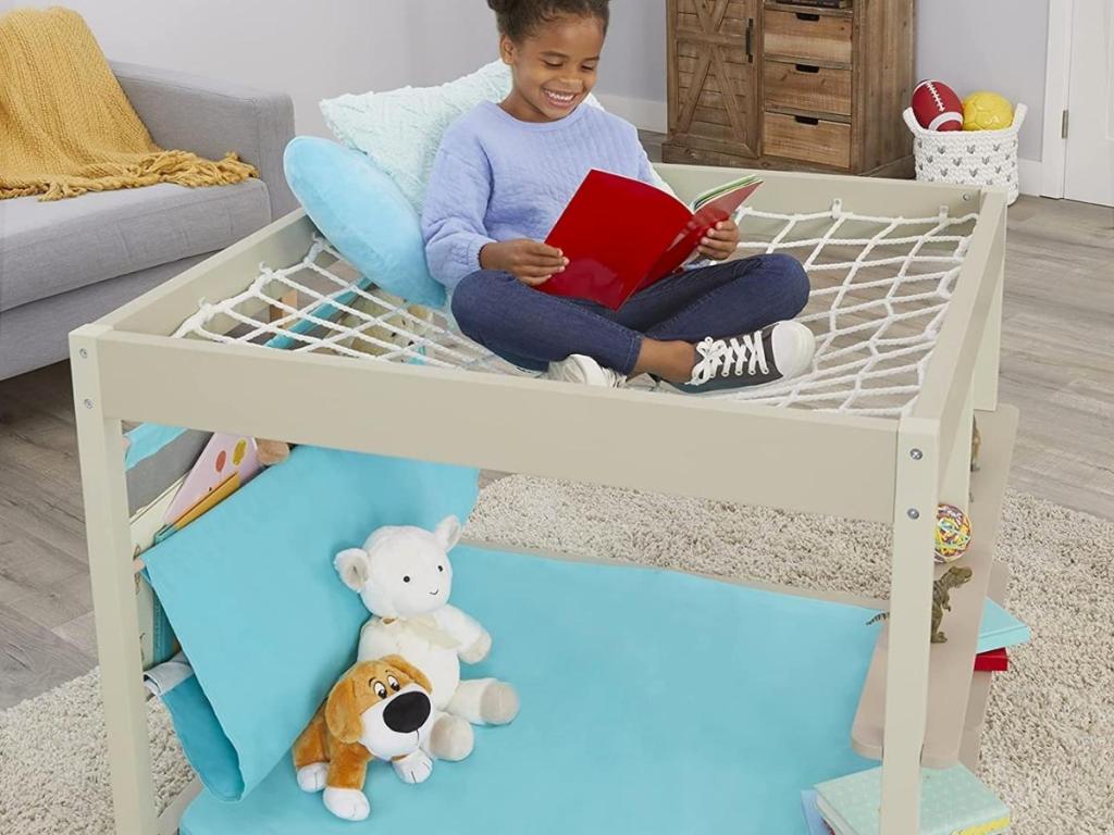 girl sitting on hanging net of little tikes read and dream nap nook