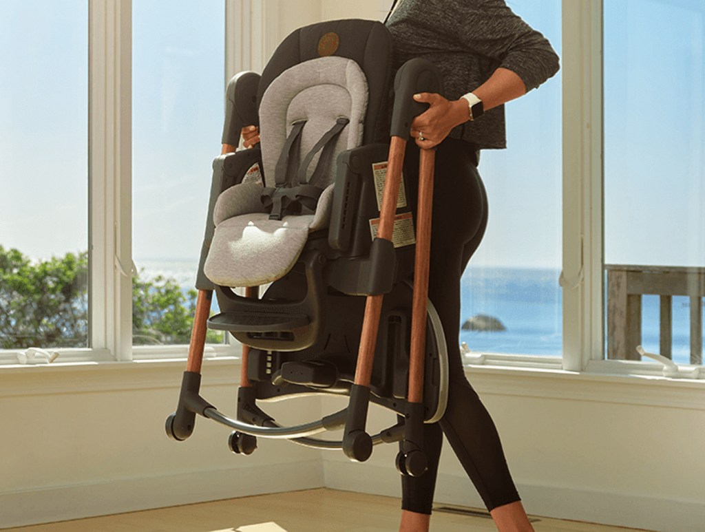 woman holding folded high chair