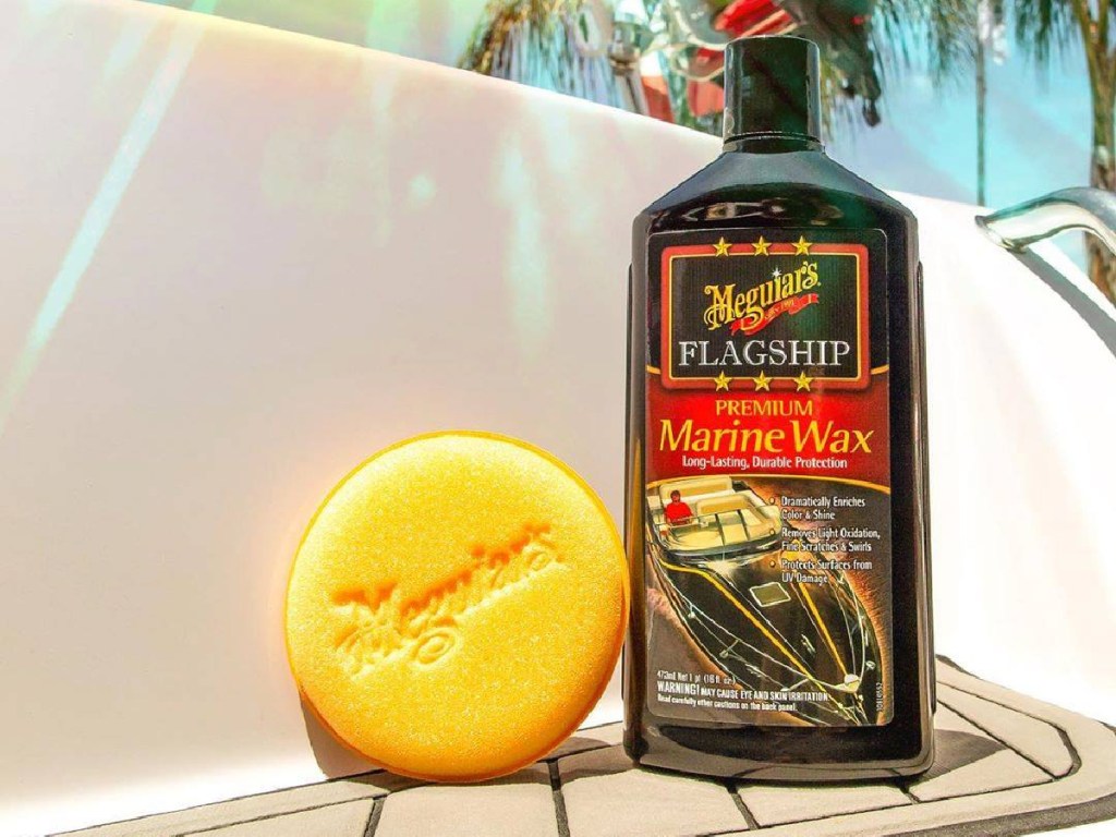 bottle of marine wax and scrubber on boat