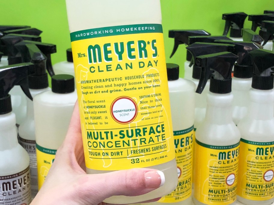 hand holding a yellow bottle of Mrs. Meyer's Clean Day Multi-Surface Cleaner Concentrate
