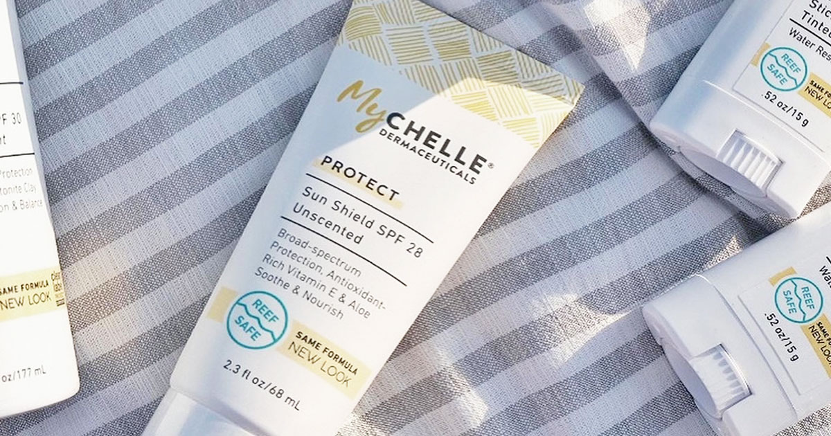 MyChelle sunscreen bottle on beach blanket