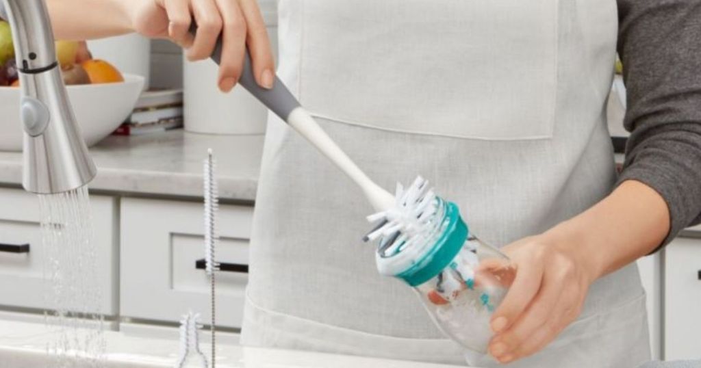 woman cleaning a bottle with a brush