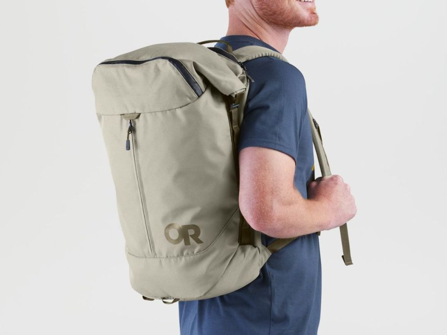 A man carrying an Outdoor Research Field Explorer Pack in Tan