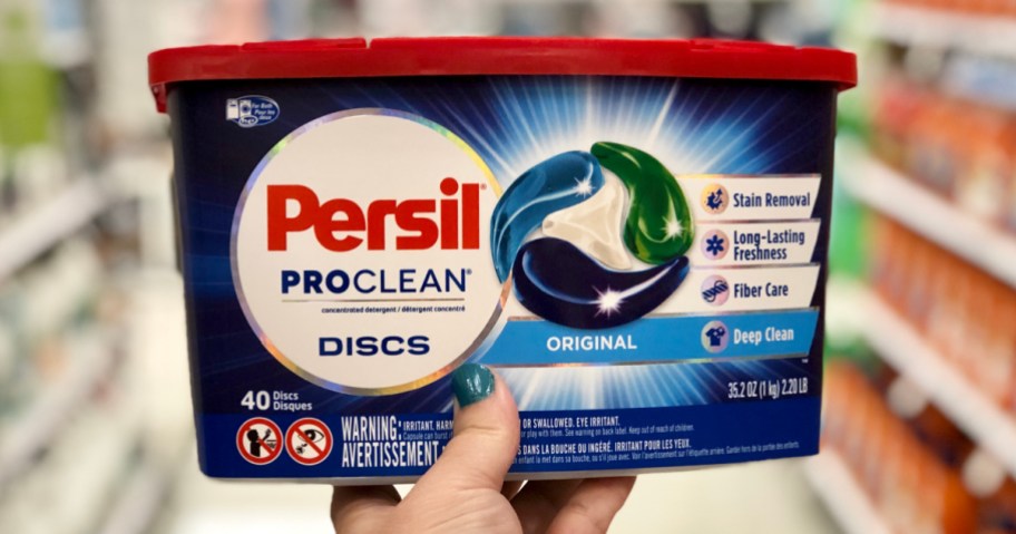 hand holding box of Persil laundry discs in store aisle