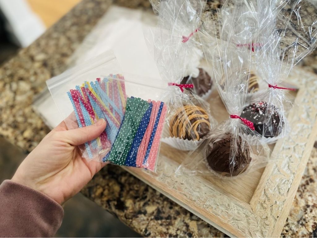 woman holding zip ties with Cellophane Bags containg chocolate treats