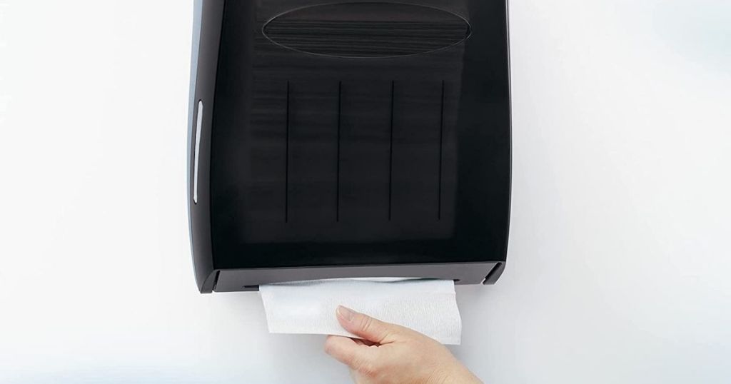 hand pulling paper towel from dispenser