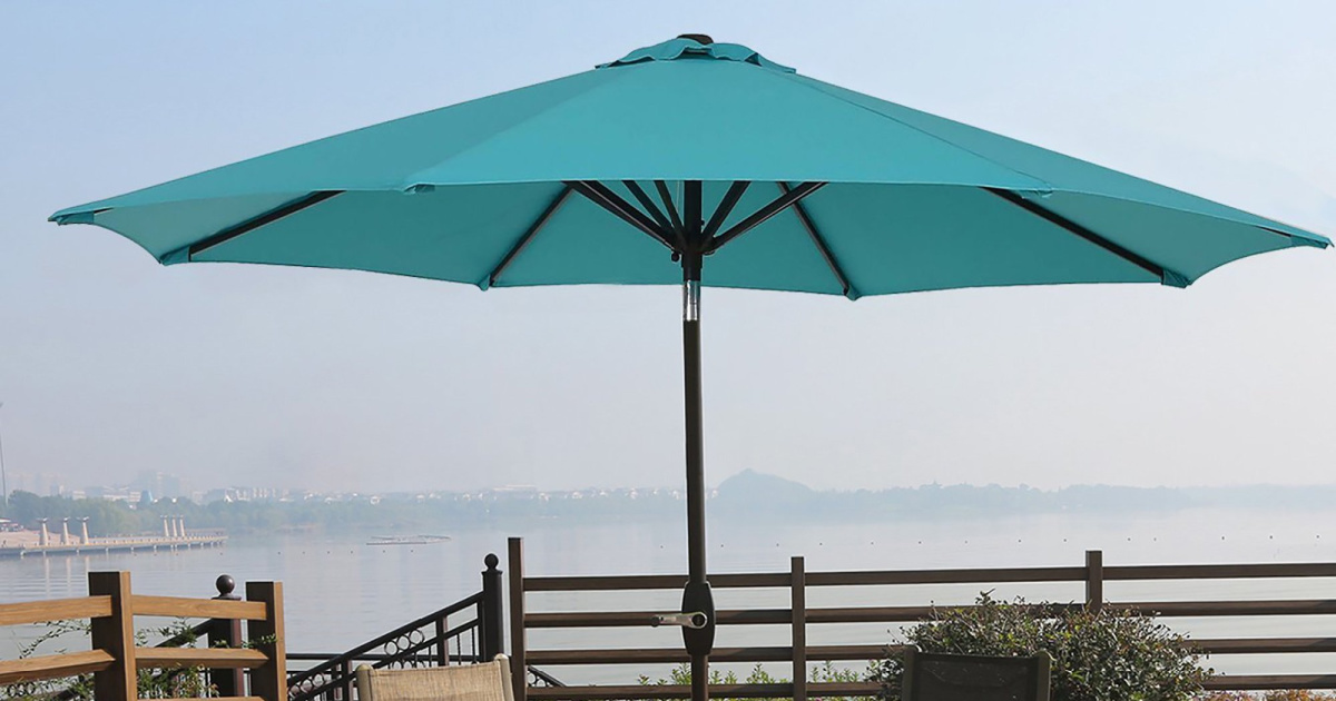turquoise colored large umbrella on patio overlooking water