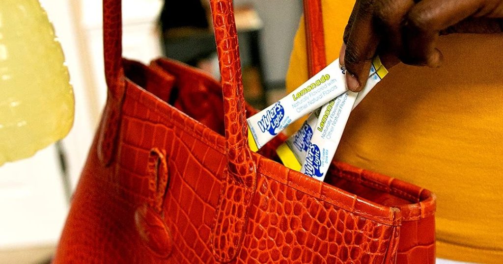 Wyler Lemonade packets being put into purse