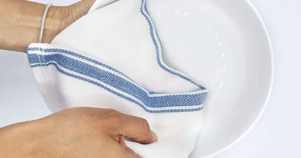 hand holding a towel and a plate