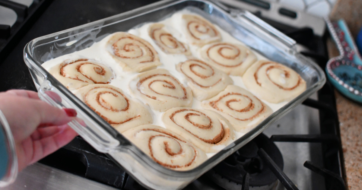 frozen cinnamon rolls with whipped cream in a baking pan