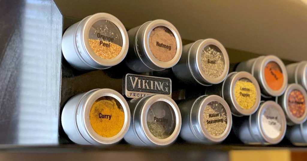 close up of magnetic spice tins sticking on black viking range hood