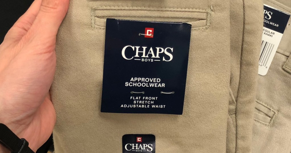 hand holding pair of khaki pants showing brand tag
