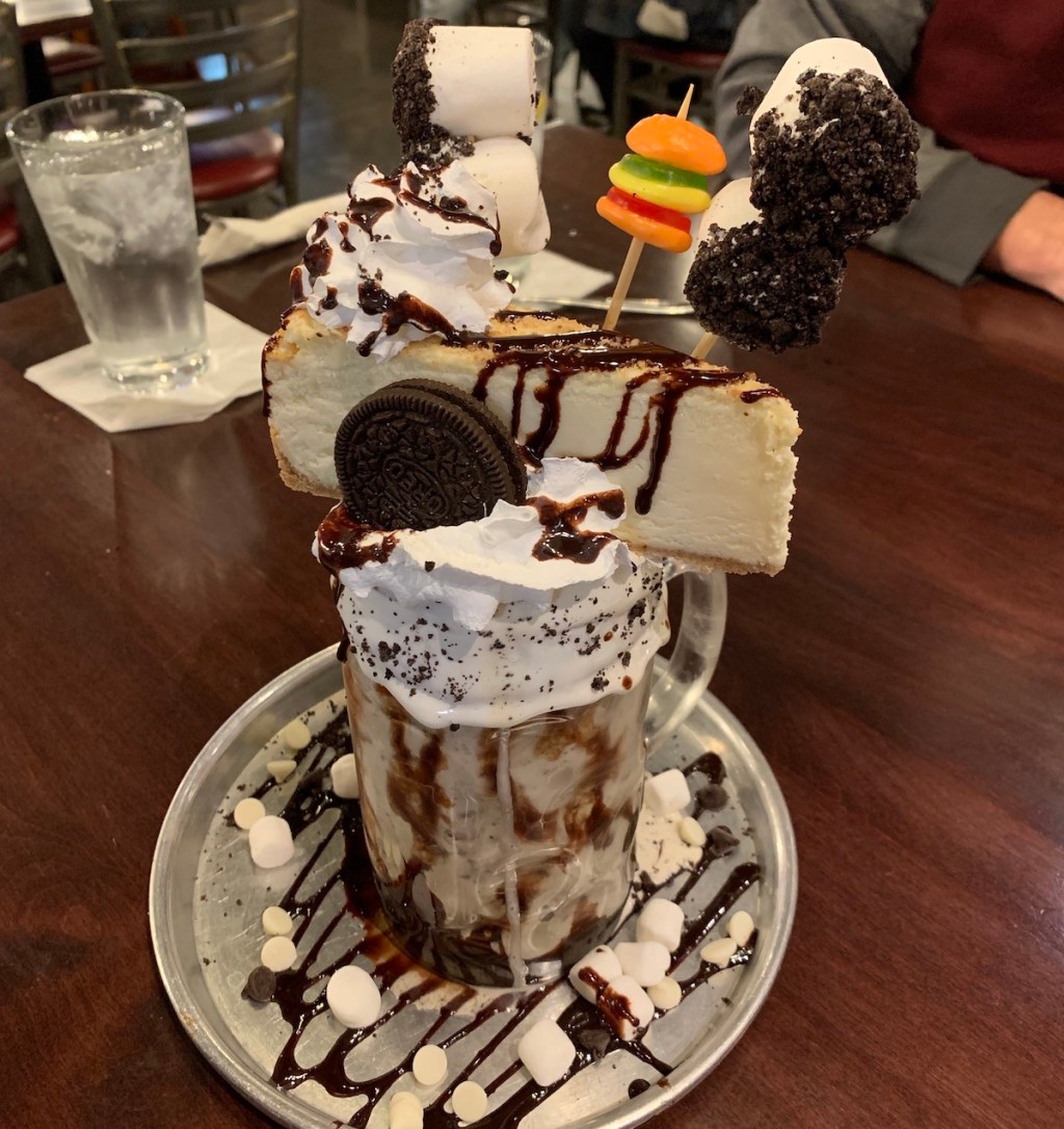 desert drink with ice cream cheesecake and other candy piled on top