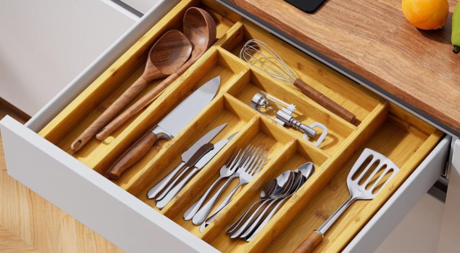 expandable bamboo drawer organizer in a drawer filled with silverware