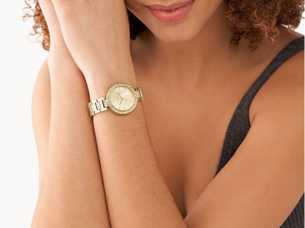 person wearing gold fossil watch