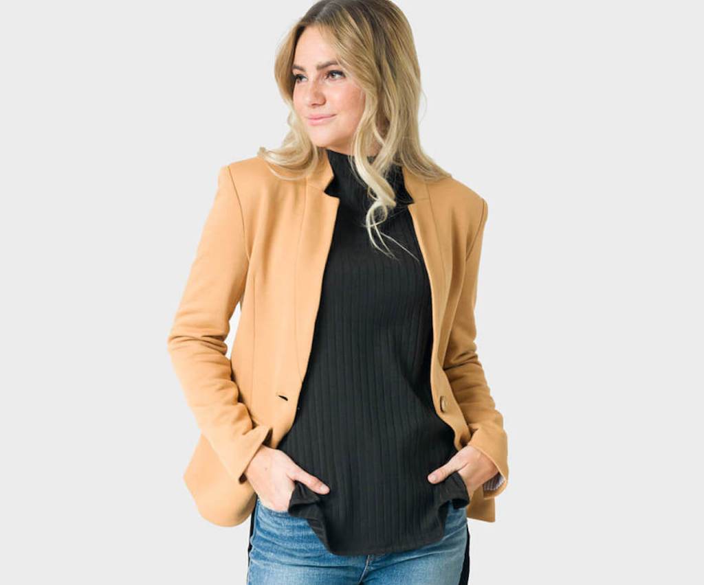 woman modeling camel colored blazer with black turtleneck shirt
