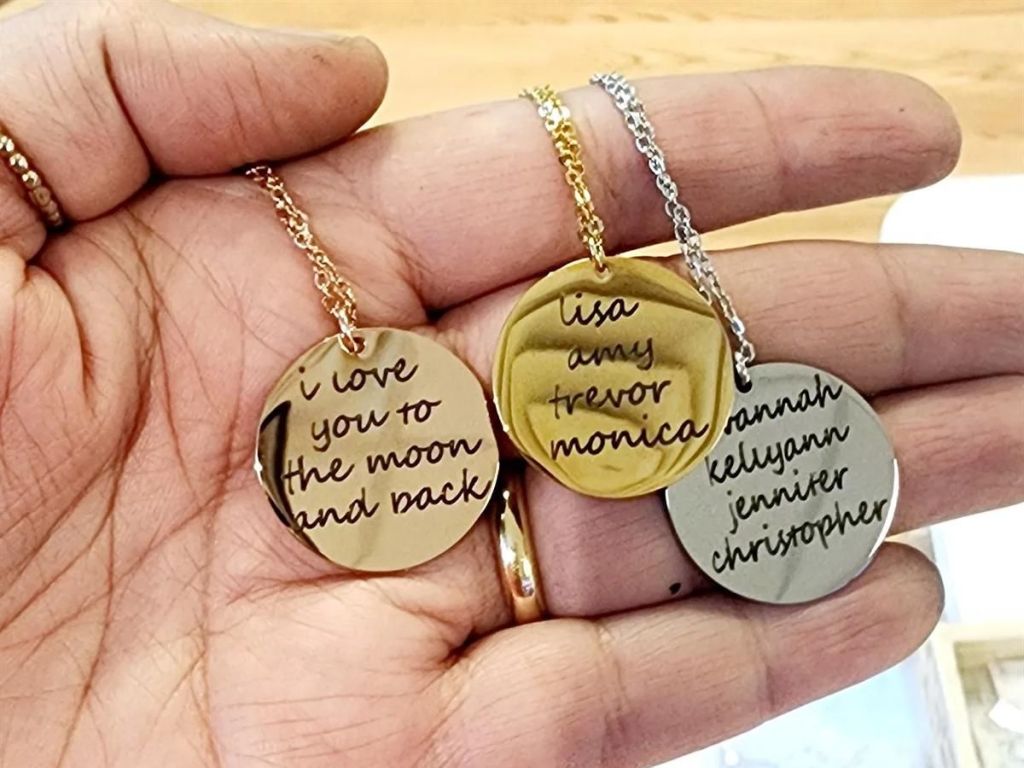 hand holding three personalized necklaces