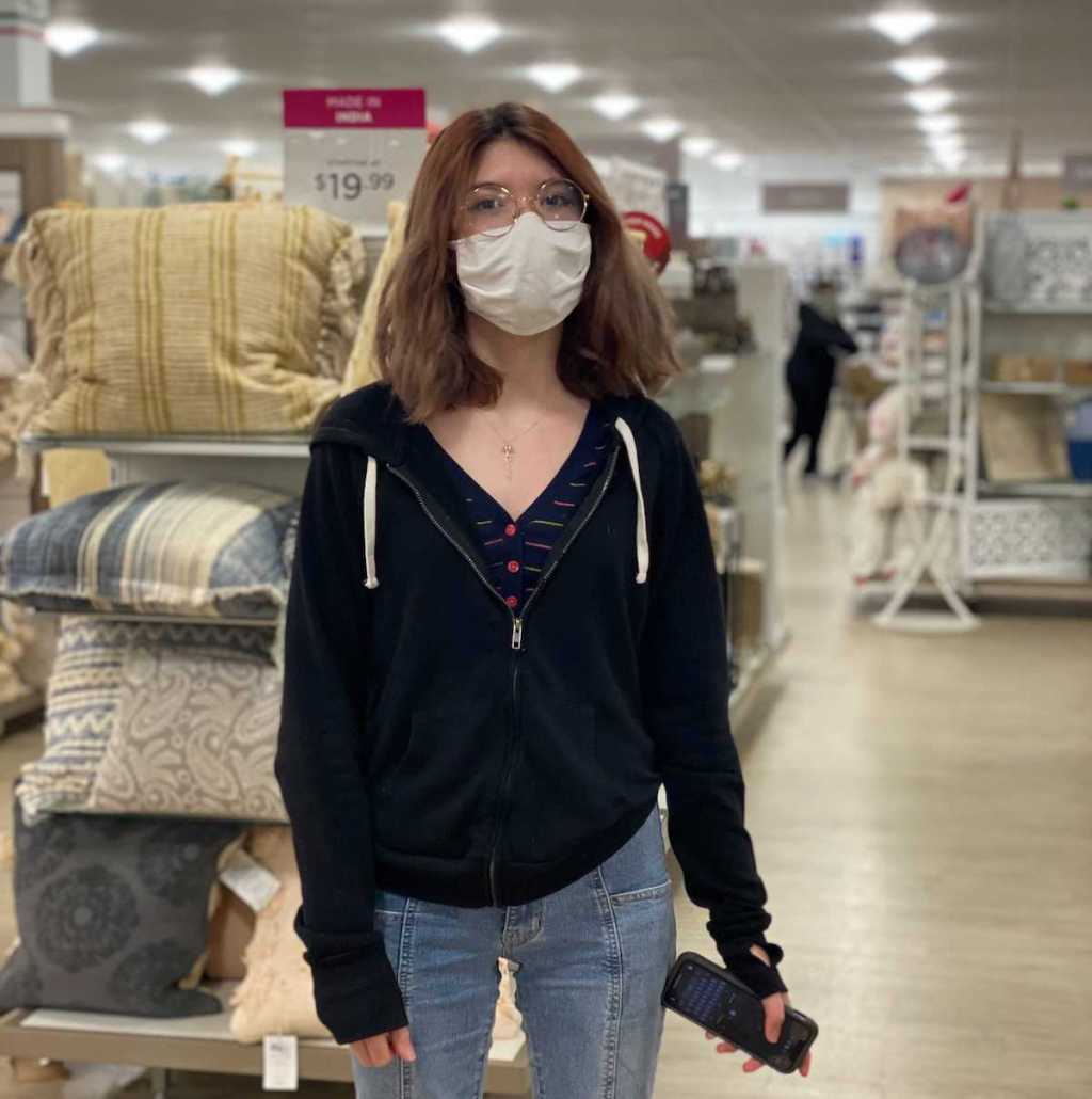 girl standing in home goods wearing a mask