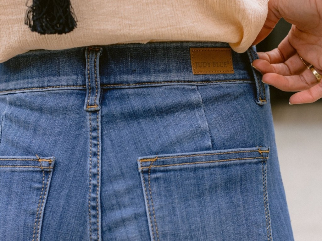 woman pulling the waistband of a pair of jeans