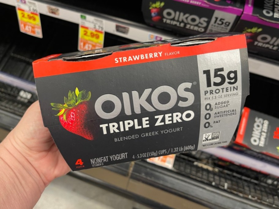 holding a 4-pack of oikos yogurt