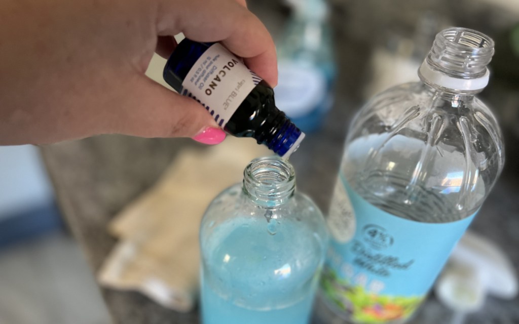 pouring diffuser oil in shower cleaner