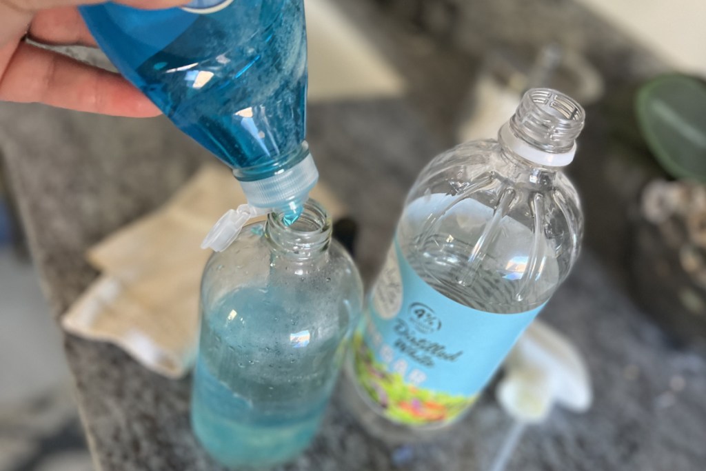 pouring dish soap in spray bottle