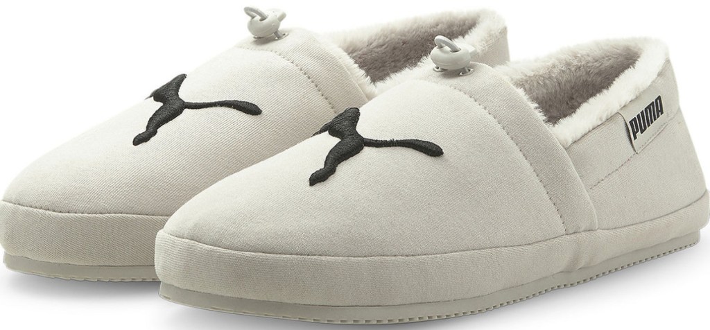 cream colored Puma slippers with puma graphic on front
