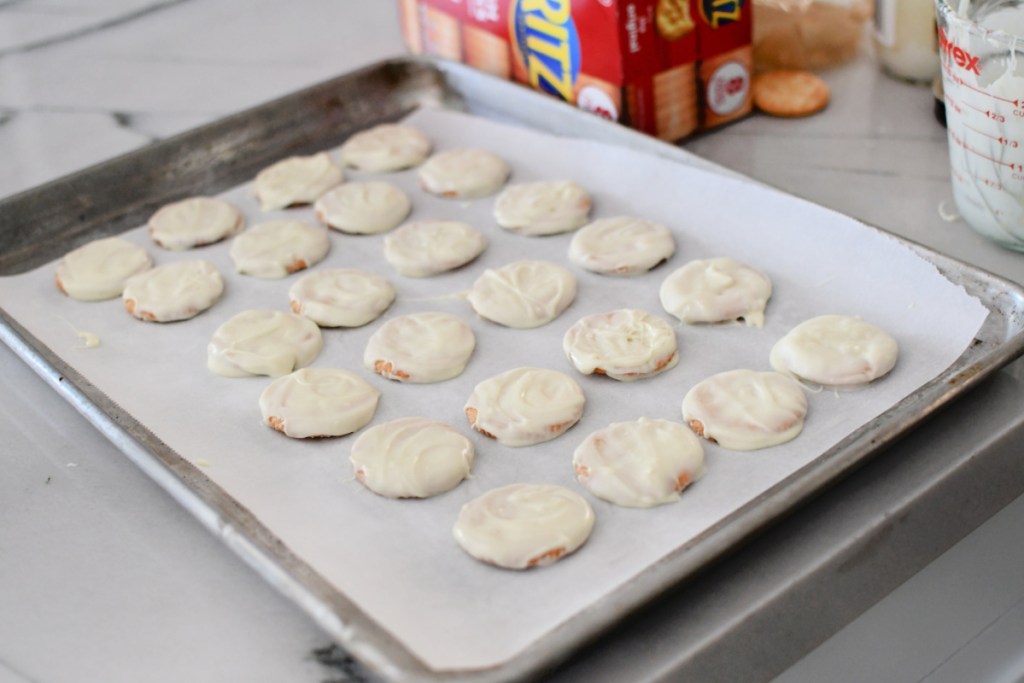 ritz crackers on parchment paper dipped in white chocolate