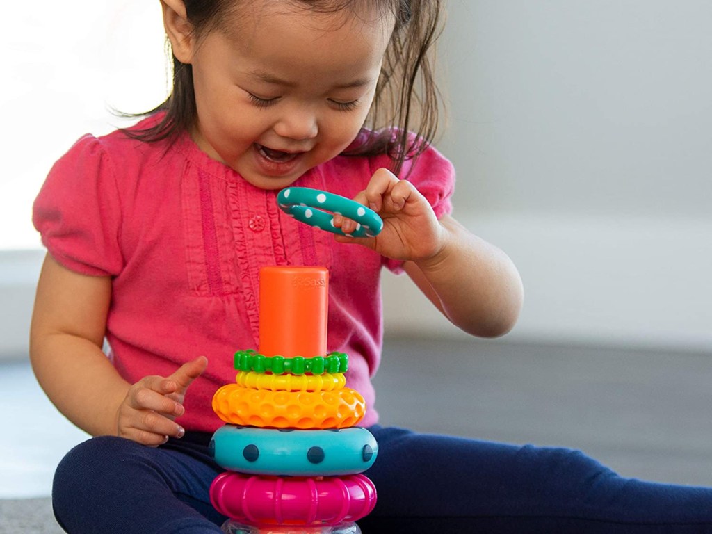 little girl using toy for stacking