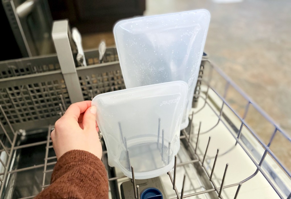 hand holding corner of clear stasher reusable silicone bag in dishwasher