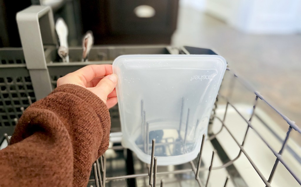 hand holding corner of clear stasher bag in dishwasher