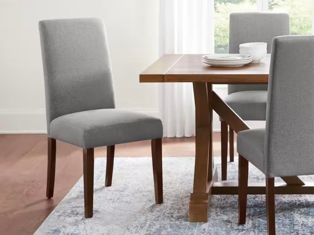 charcoal fabric dining chairs next to brown table