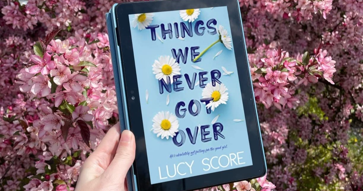 holding the kindle version of Things We Never Got Over book