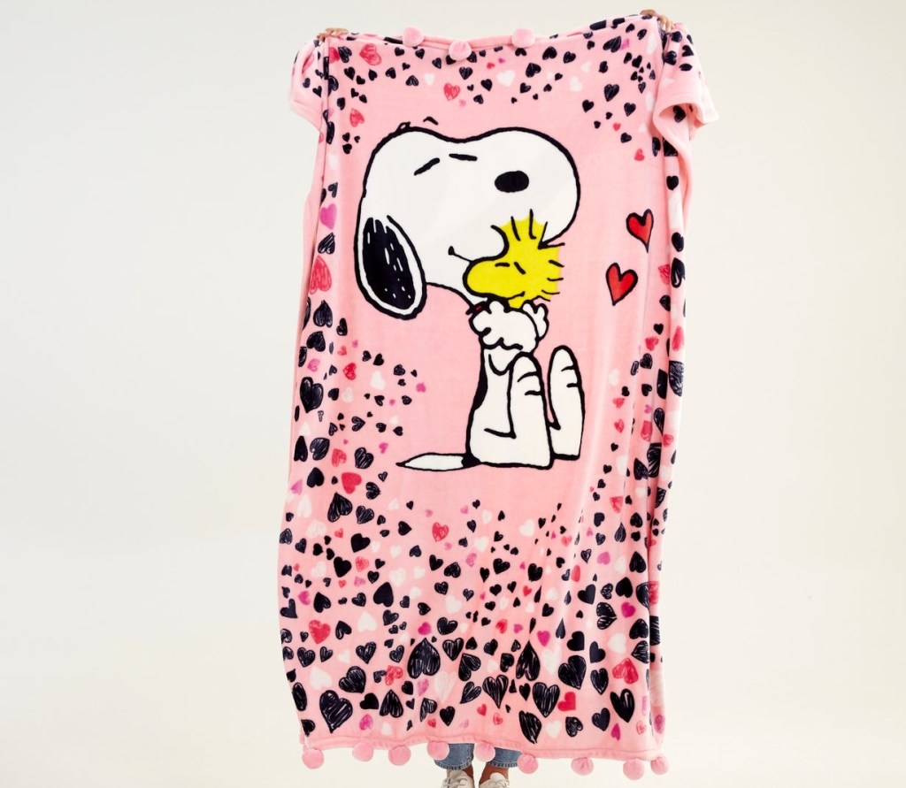 holding up a pink Snoopy blanket