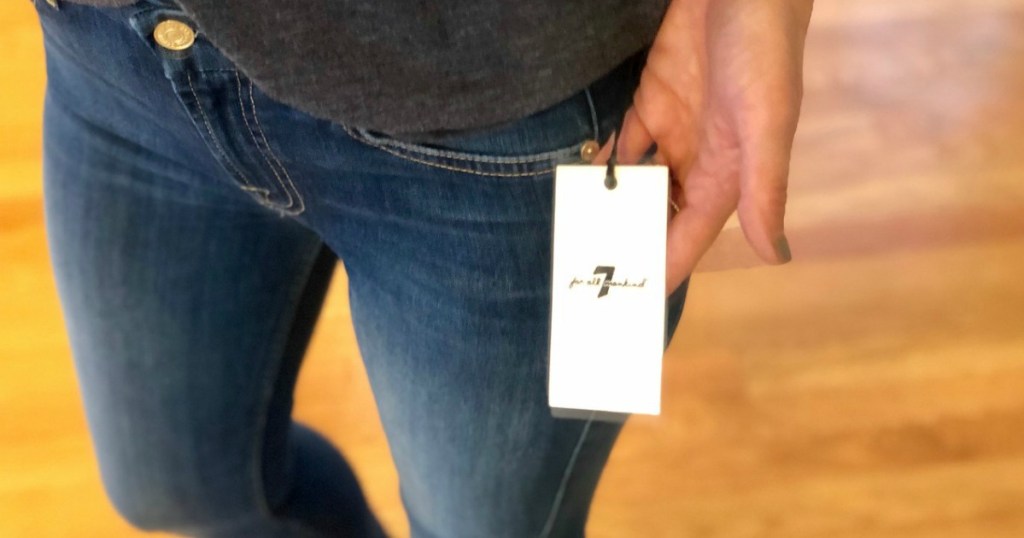 hand holding a tag on a pair of jeans