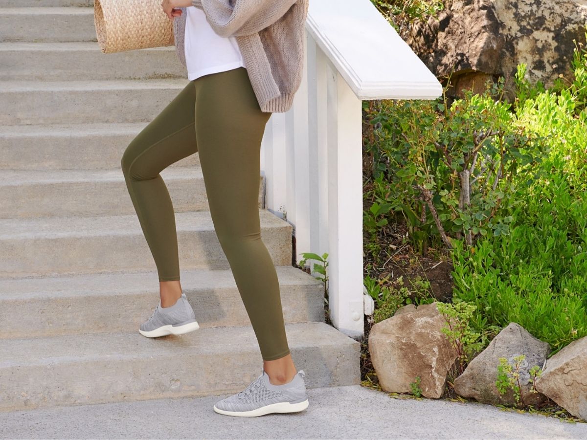 woman wearing green leggings and gray LifesStride sneakers walking up the steps
