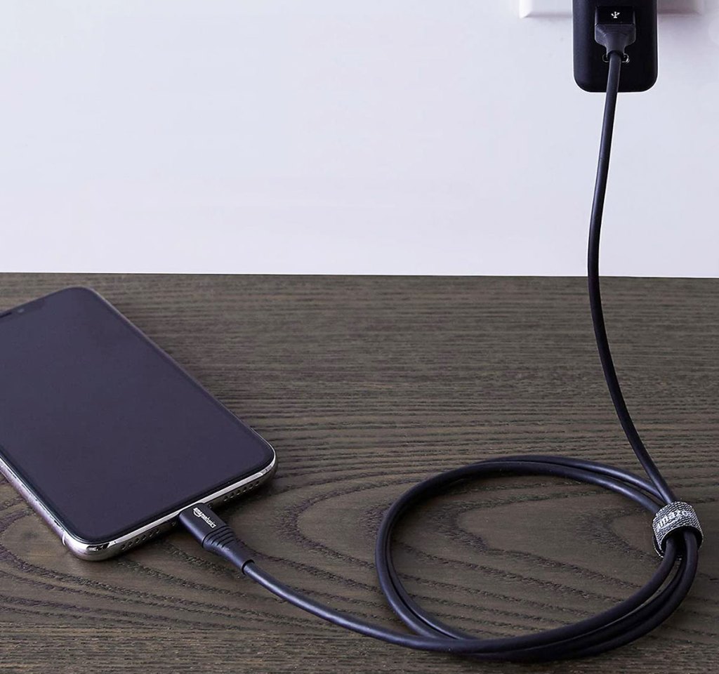 black charging cable plugged into iphone and wall adapter