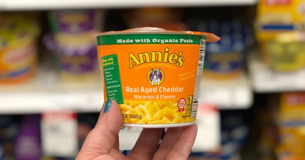 hand holding up a cup of Annie real aged cheddar mac & cheese