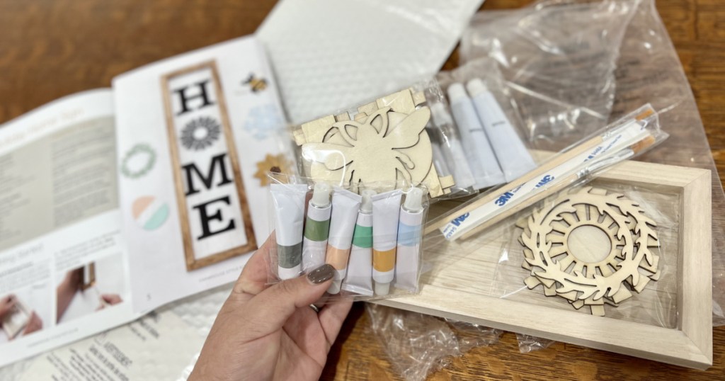 person holding paint supplies to make homemade wooden home sign