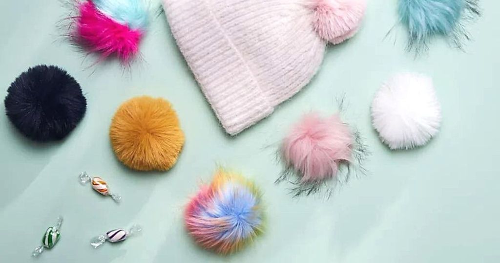 colorful poms and pink knit hat