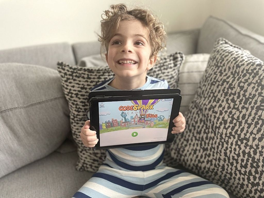 boy holding up tablet with CodeSpark app