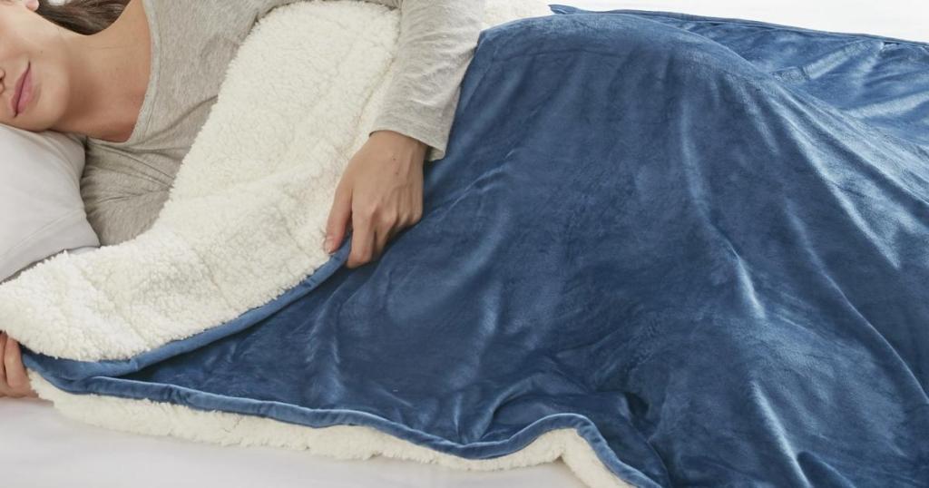 woman sleeping under Comfort Spaces Velvet to Berber 10lbs Navy Reversible Weighted Blanket